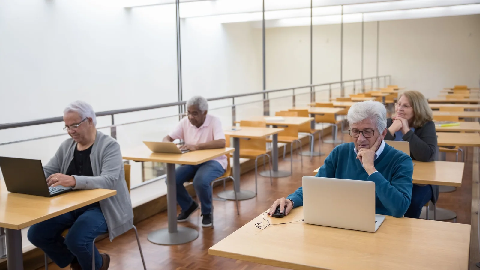 Des personnes âgées utilisent des ordinateurs portables lors d’un atelier numérique