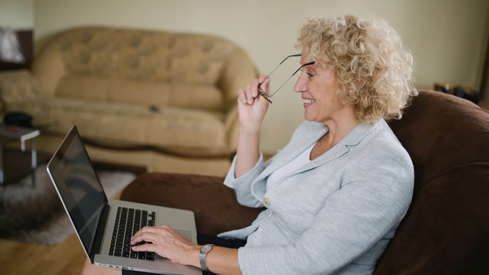 Une femme senior compare des offres de complémentaire santé sur son ordinateur portable