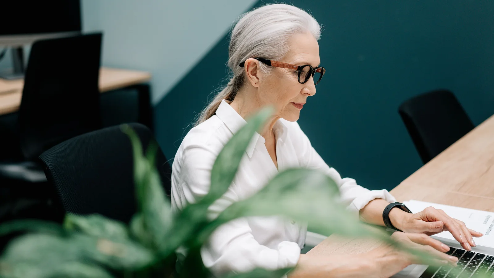 Une femme senior travaille sur un ordinateur portable dans un bureau